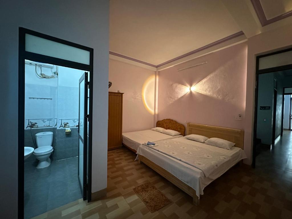 a bedroom with a bed and a shower and a toilet at Tiến Minh Hotel cầu Pắc Ta in Pắc Ta