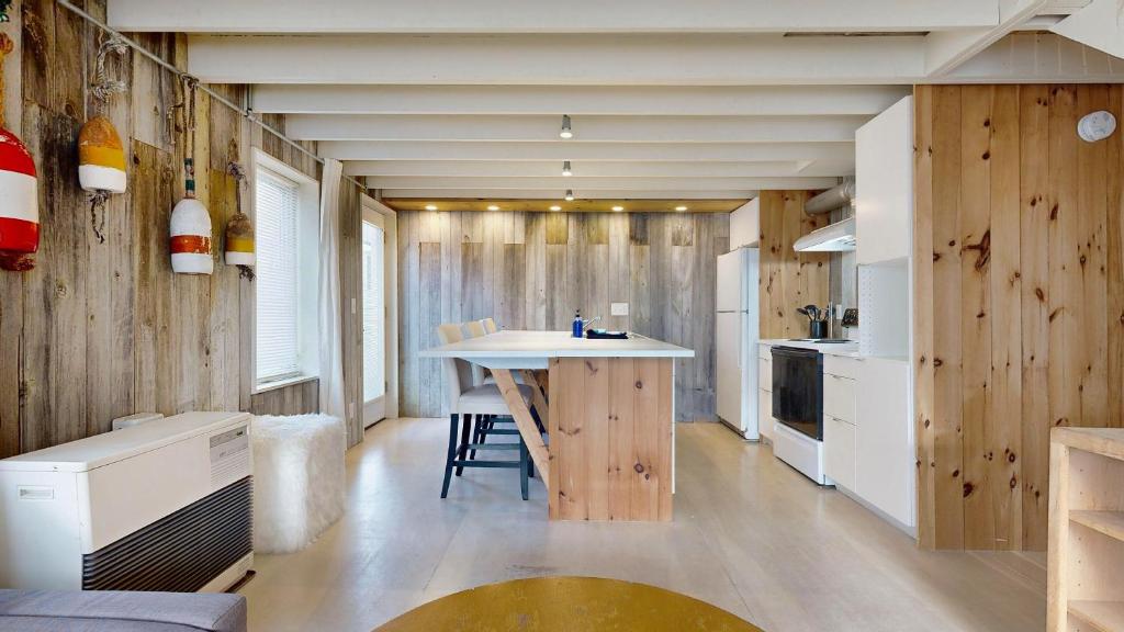 a kitchen with wooden walls and a table in a room at Tide & Timber by Bayley Vacation Rentals in Old Orchard Beach