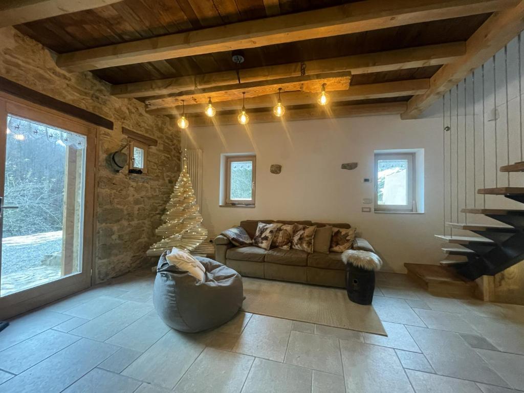 un soggiorno con un divano e un muro di pietra di Al Foér Guesthouse ad Averara