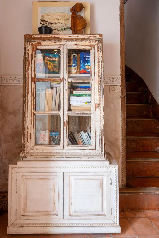 un vieux meuble à livres à côté d'un escalier dans l'établissement Riad le Jardin de Mina, à Marrakech