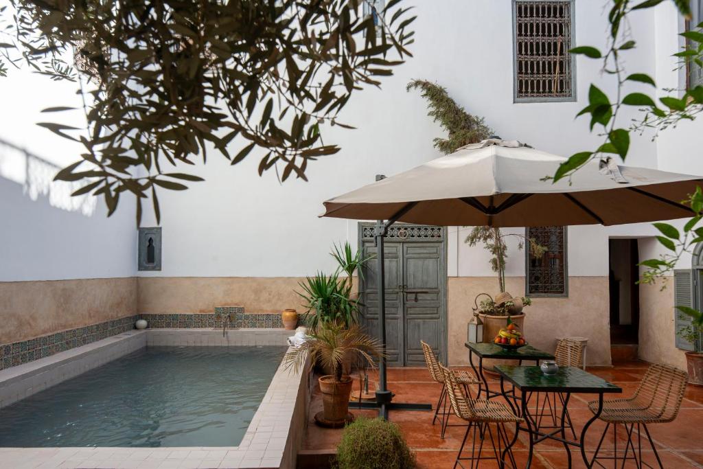 - un billard avec des tables, des chaises et un parasol dans l'établissement Riad le Jardin de Mina, à Marrakech