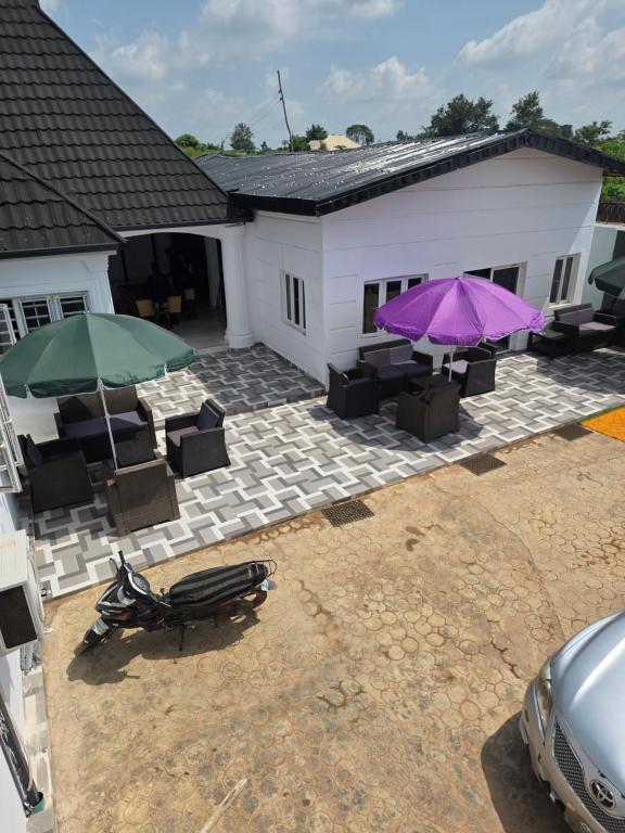 an overhead view of a patio with two umbrellas and chairs at Umbrella Properties hotels and apartments - Moniya in Ibadan
