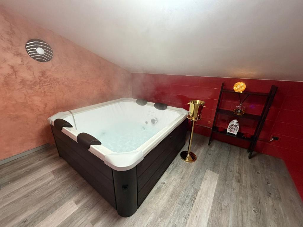 Atena B&B APARTMENTS Imperial في San Silvestro: حوض استحمام في غرفة بجدار احمر