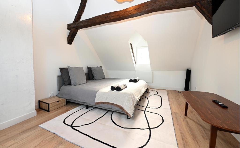 ein Schlafzimmer mit einem Bett und einem Holztisch in der Unterkunft Le Sens - Duplex 4 pers - Love Room - Jacuzzi in Sens