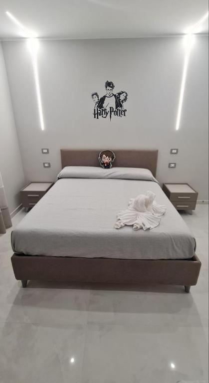 a bedroom with a bed and a sign on the wall at B&B Grifondoro in Crotone