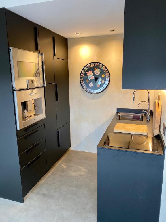 a kitchen with a counter and a sink and a clock at La Saulzaie in L'Ile d'Yeu