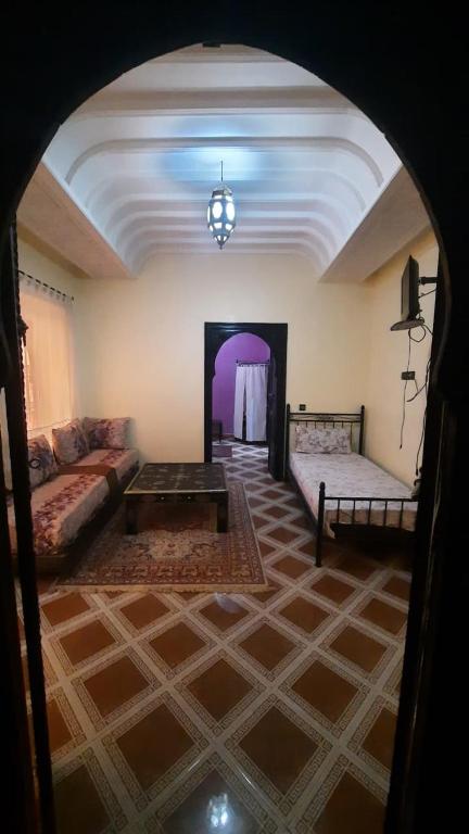 una sala de estar con un sofá y una mesa en Riad Des Artistes, en Oulad Akkou