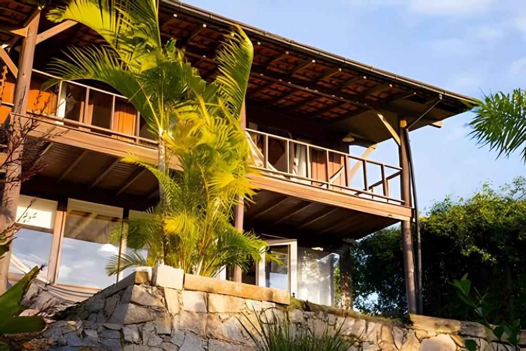 una casa con una palma di fronte di Casa Fluila a Praia do Rosa