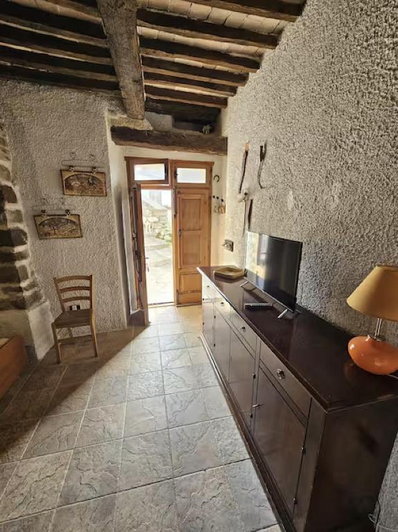 a kitchen with a counter with a television and a table at La Casetta nella Roccia in Torricella Peligna