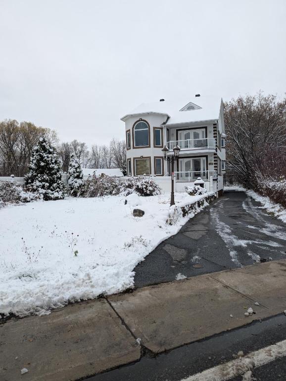 a large house with snow on the ground at Waterfront apartment in Gatineau