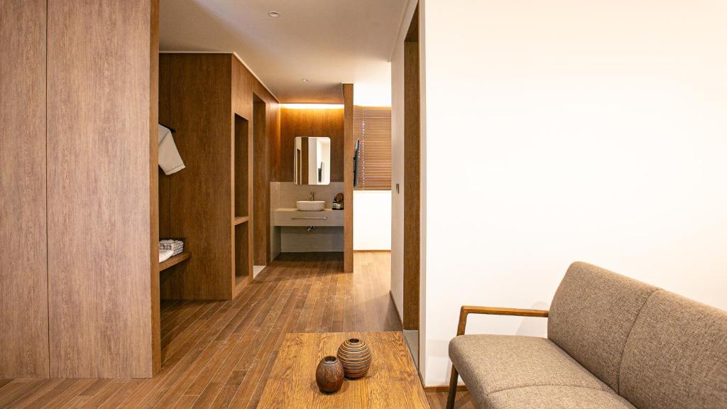a living room with a couch and a kitchen at Hotel Yimok in Busan