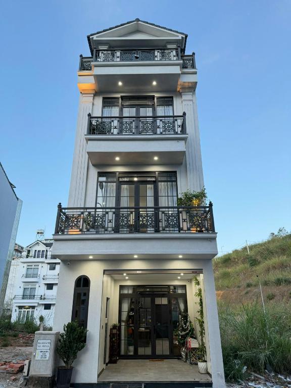 a tall white building with a balcony at Prova Home in Da Lat