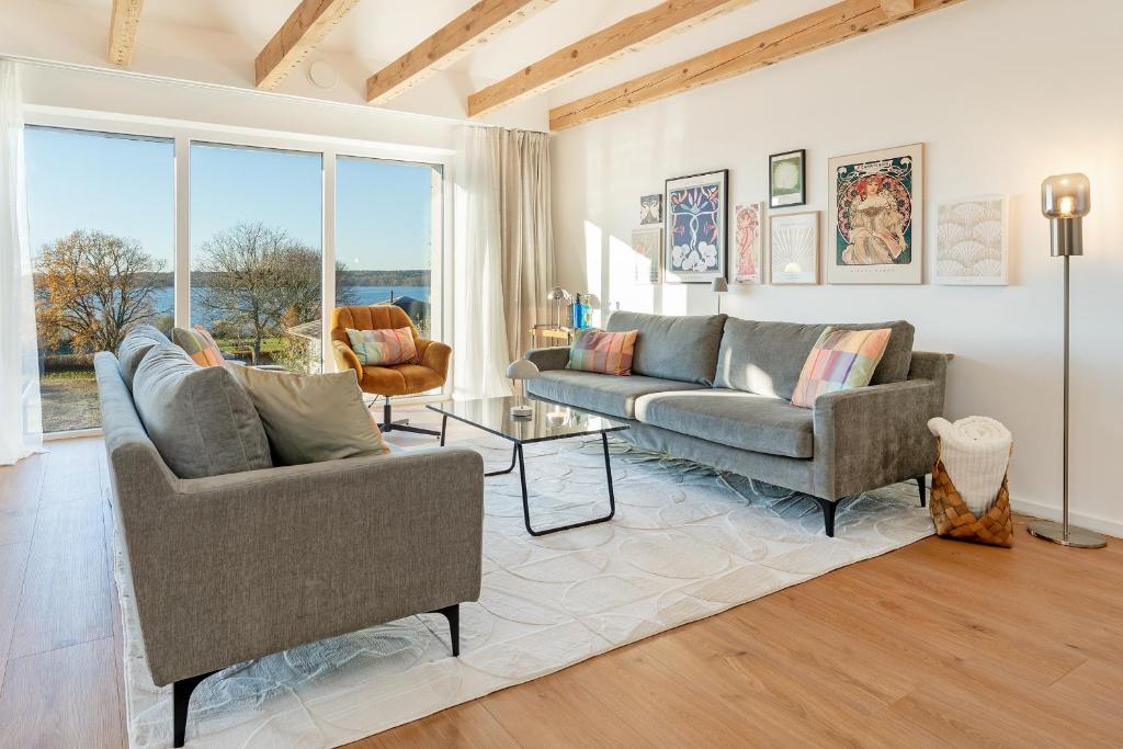 un soggiorno con due divani e una grande finestra di Gollings am See Loft-Suite a Bosau