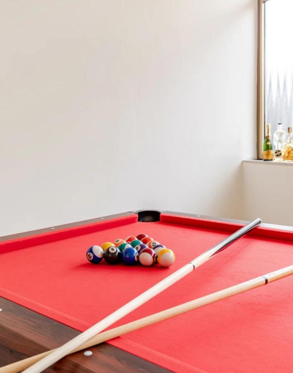 a red pool table with three cue balls on it at Ca`del Fuin in Seregno