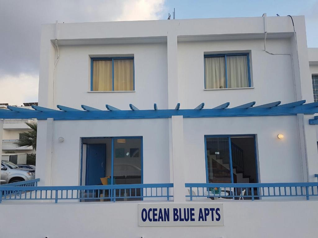 Biały budynek z niebieskimi akcentami na boku w obiekcie Ocean Blue Apartments w Pafos