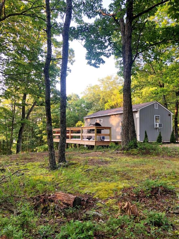 a trailer in the middle of a field with trees at Camp Carter Tiny House in Mathias