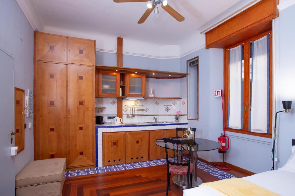 a kitchen with wooden cabinets and a table in a room at ArtStay Apt Sempione, Near Metro, City Centre in Milan