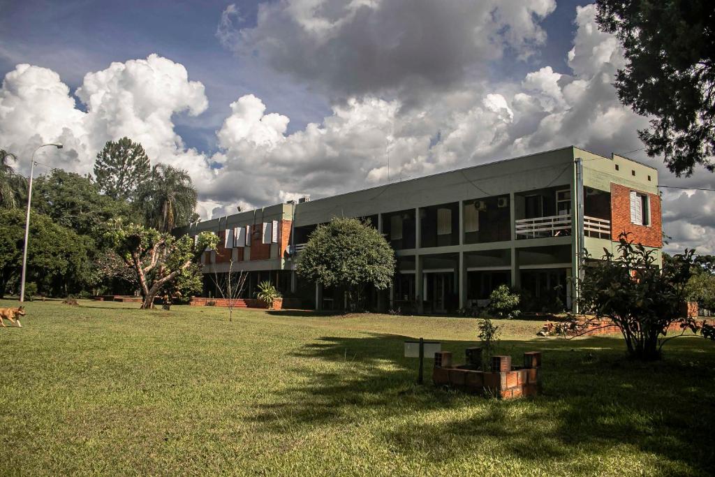 a building with a grass field in front of it at Puerto Mineral Hotel & Golf in Capioví