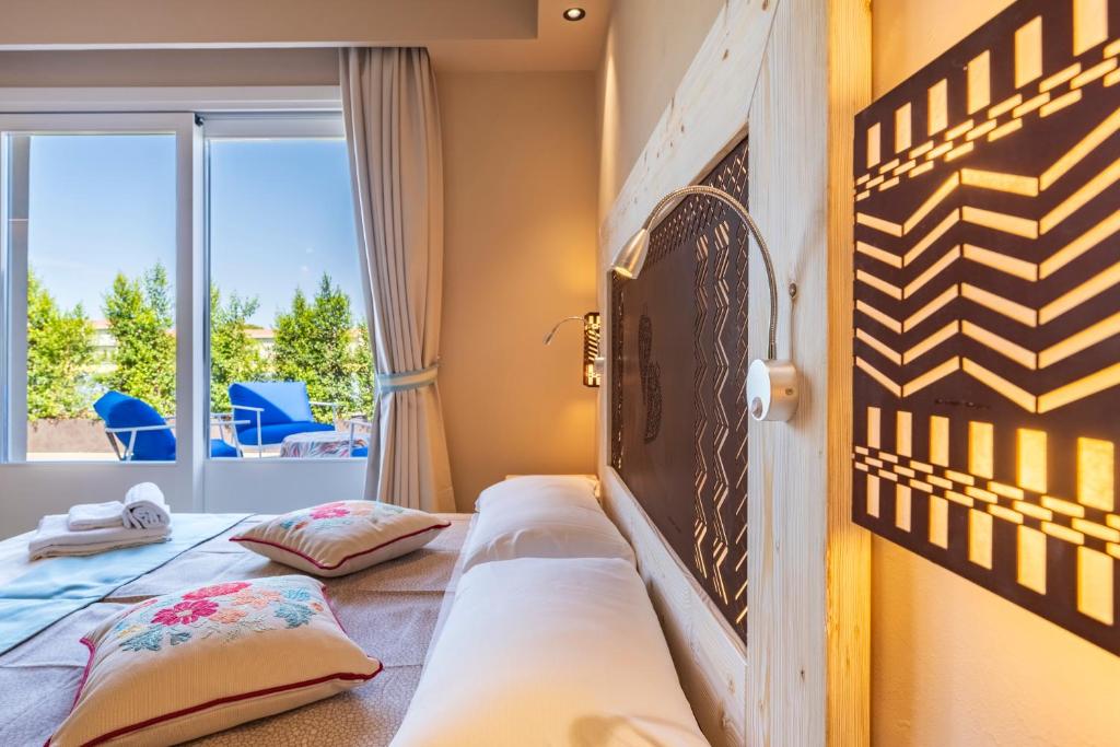 une chambre avec un lit avec des oreillers et une fenêtre dans l'établissement Sogno, à Tortolì