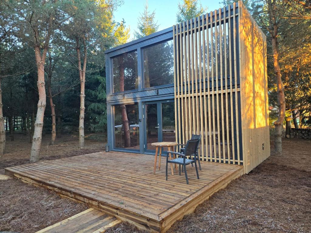 The Nut House - Cozy Escape in Tartu في Soinaste: منزل به طاولة وكرسي على سطح خشبي