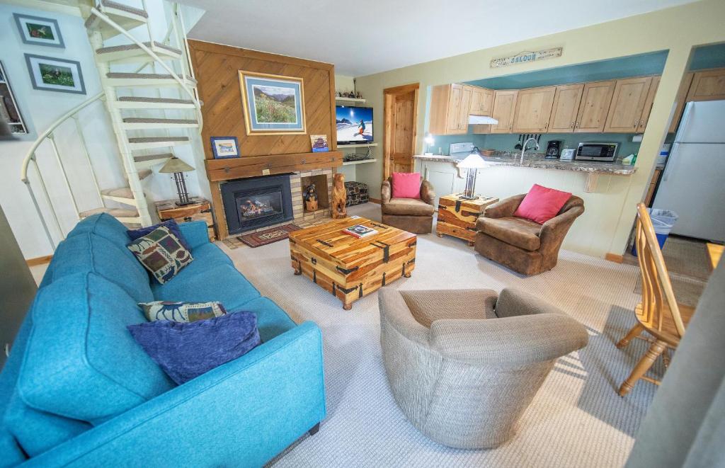 a living room with a blue couch and a fireplace at Flying Dutchman 1192 by SummitCove Lodging in Keystone