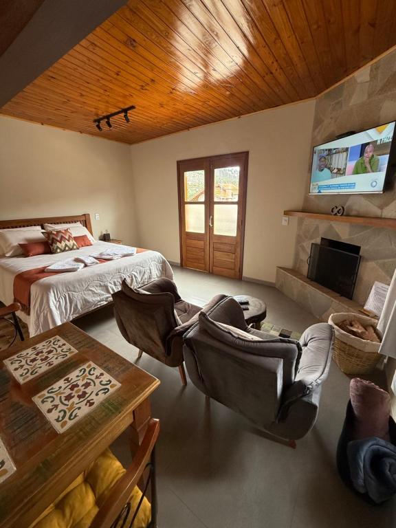 a bedroom with a bed and a tv in a room at Chalé Vista Verde in Monte Verde