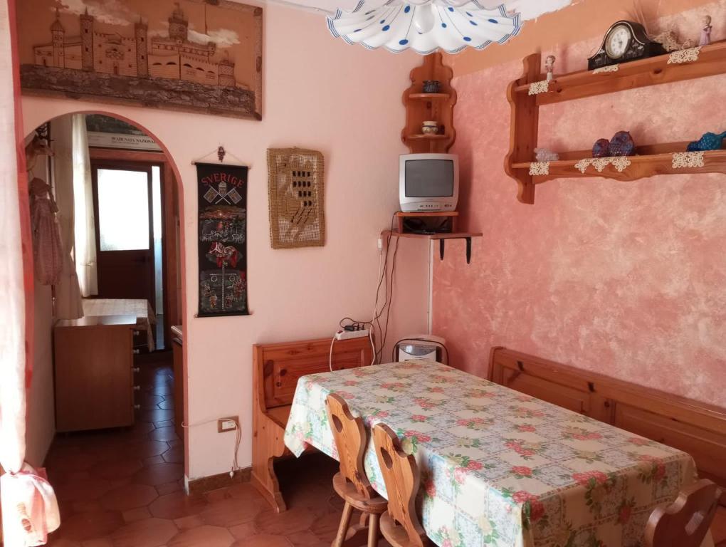 Habitación con mesa y TV. en Casa vacanze Ginevra Sardegna, en Fluminimaggiore