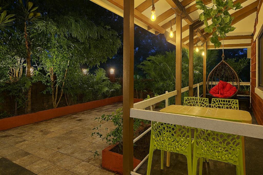 uma mesa e cadeiras num alpendre à noite em Gulmohar Villa tamhini ghat, Kolad Rafting 