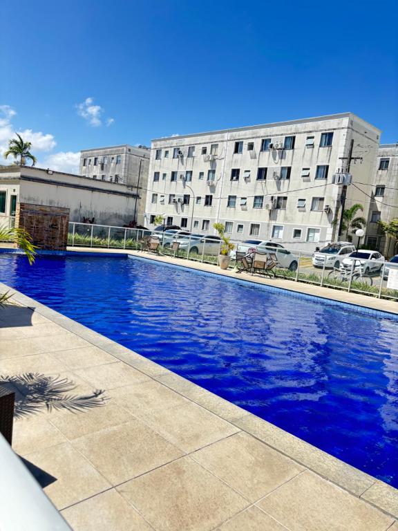 een groot blauw zwembad voor een gebouw bij Recanto do Sol, 2 quartos, piscina ambiente tranquilo in Recife