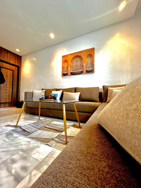 a living room with a couch and a table at Chic Cocoon & Impeccable Sea View in Zenata in Aïn Harrouda
