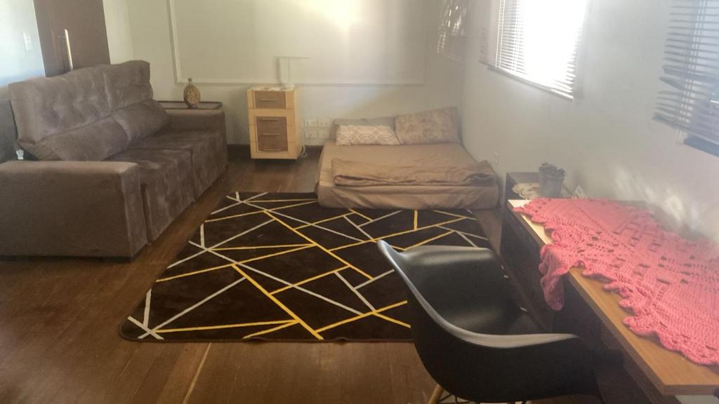 a living room with a couch and a chair at Med House in Guaíra