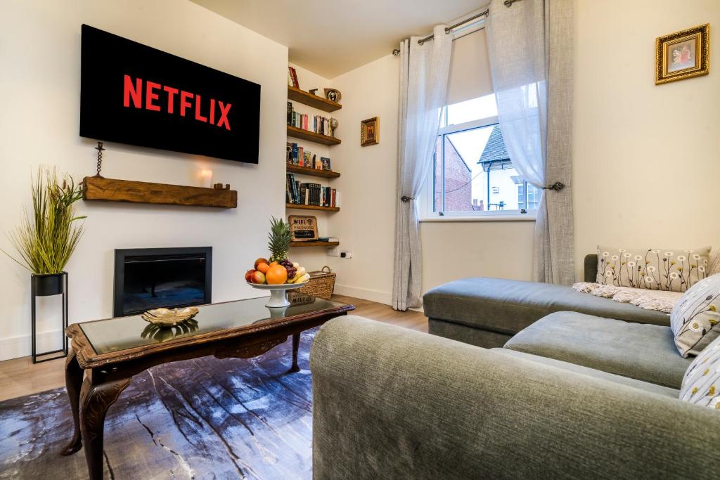 a living room with a couch and a table at Enigma Lodge in Stratford-upon-Avon