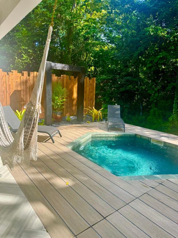 a patio with a hammock and a swimming pool at Chaya Lodge in Petit-Bourg