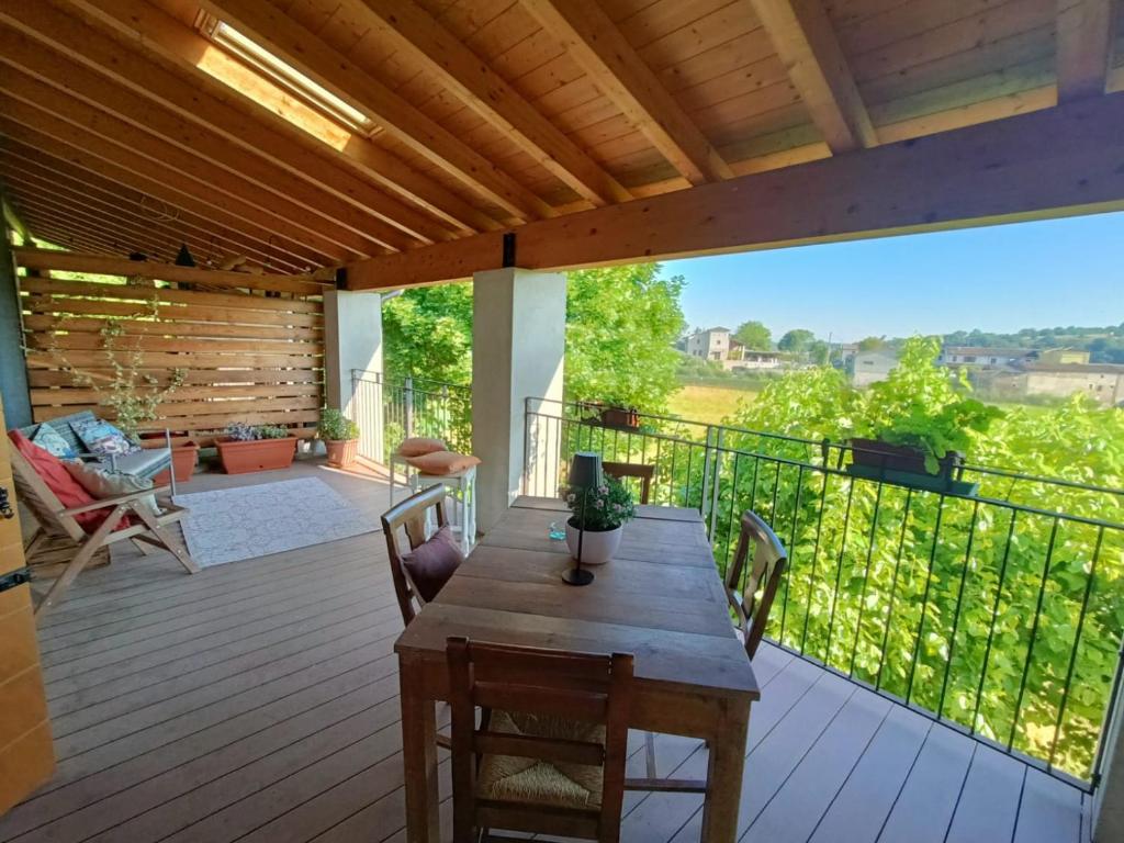 a wooden deck with a table and chairs on it at Agribirrificio Corte Petacchi in Volta Mantovana