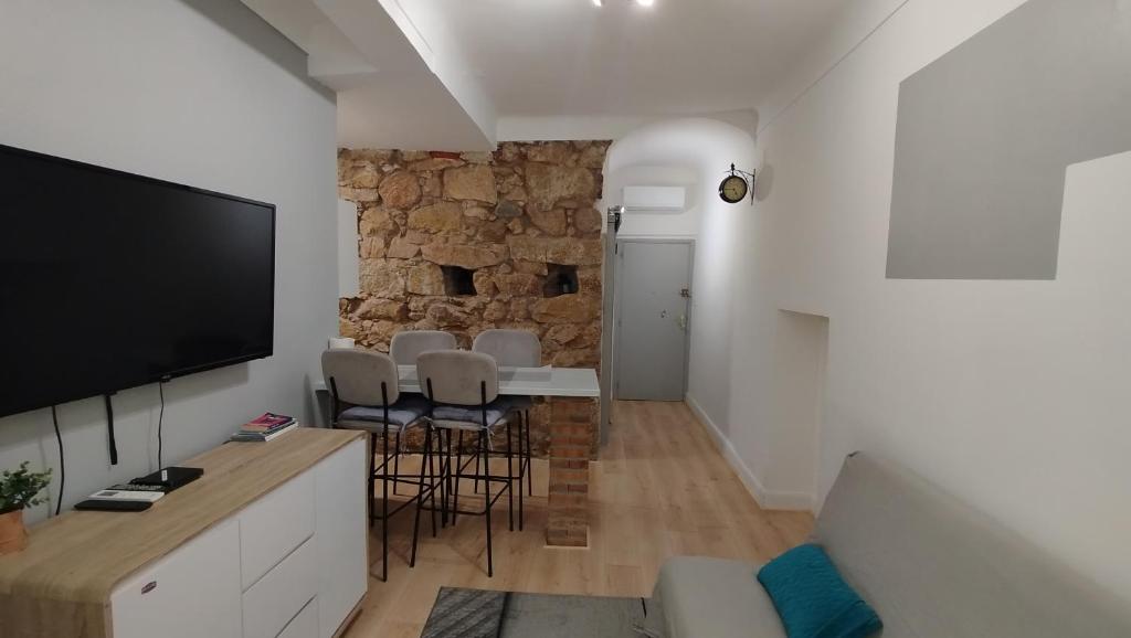 een woonkamer met een tv en een stenen muur bij T2 type new yorkais in Ajaccio