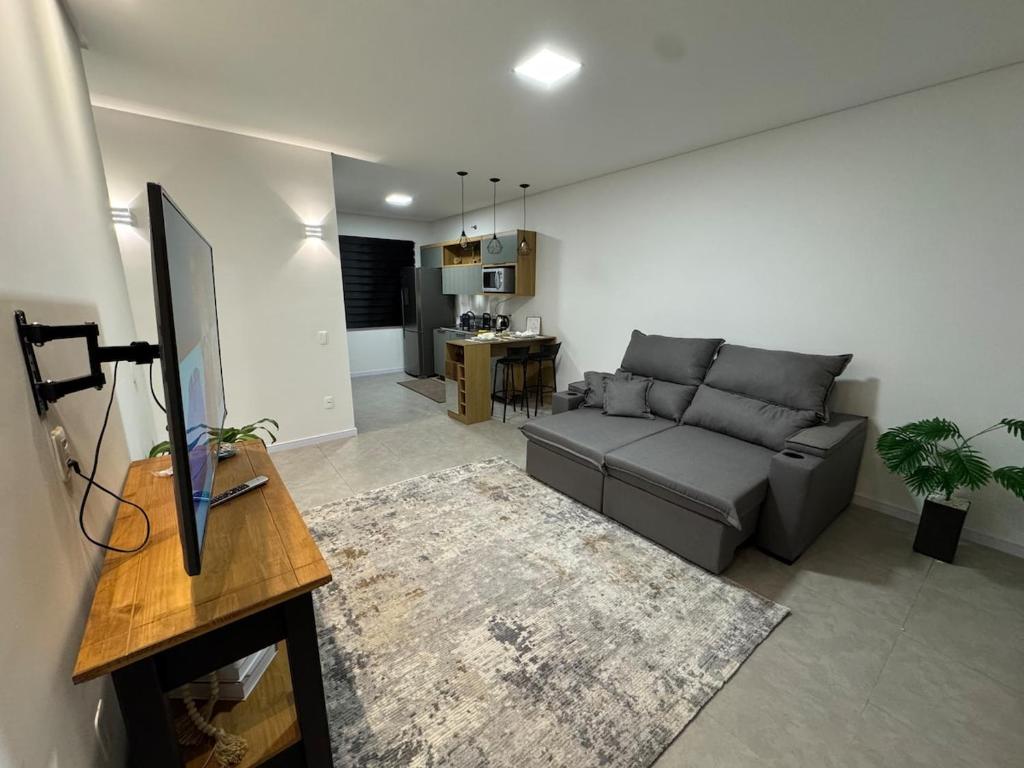 un soggiorno con un divano e un tavolo di Casa Nova & Aconchegante a São Bento do Sul