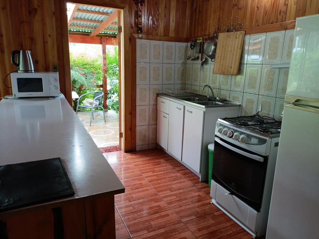 een keuken met een fornuis en een aanrechtblad bij Cabañas Mis Nietos in Licán Ray