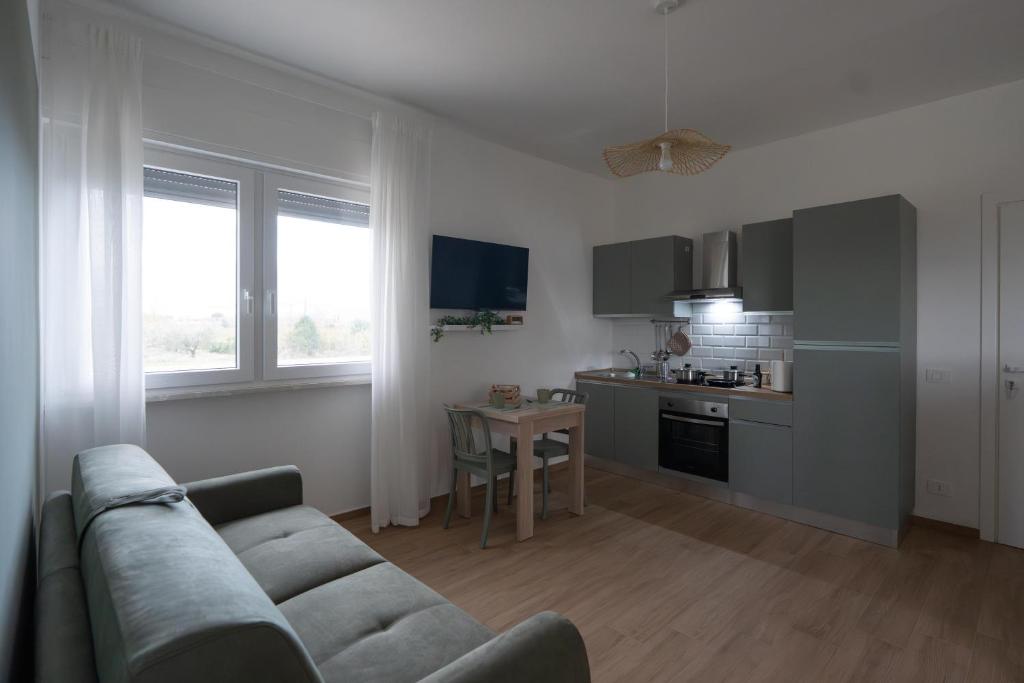 een woonkamer met een bank en een keuken bij Casa di Viola - Ortensia in Latina