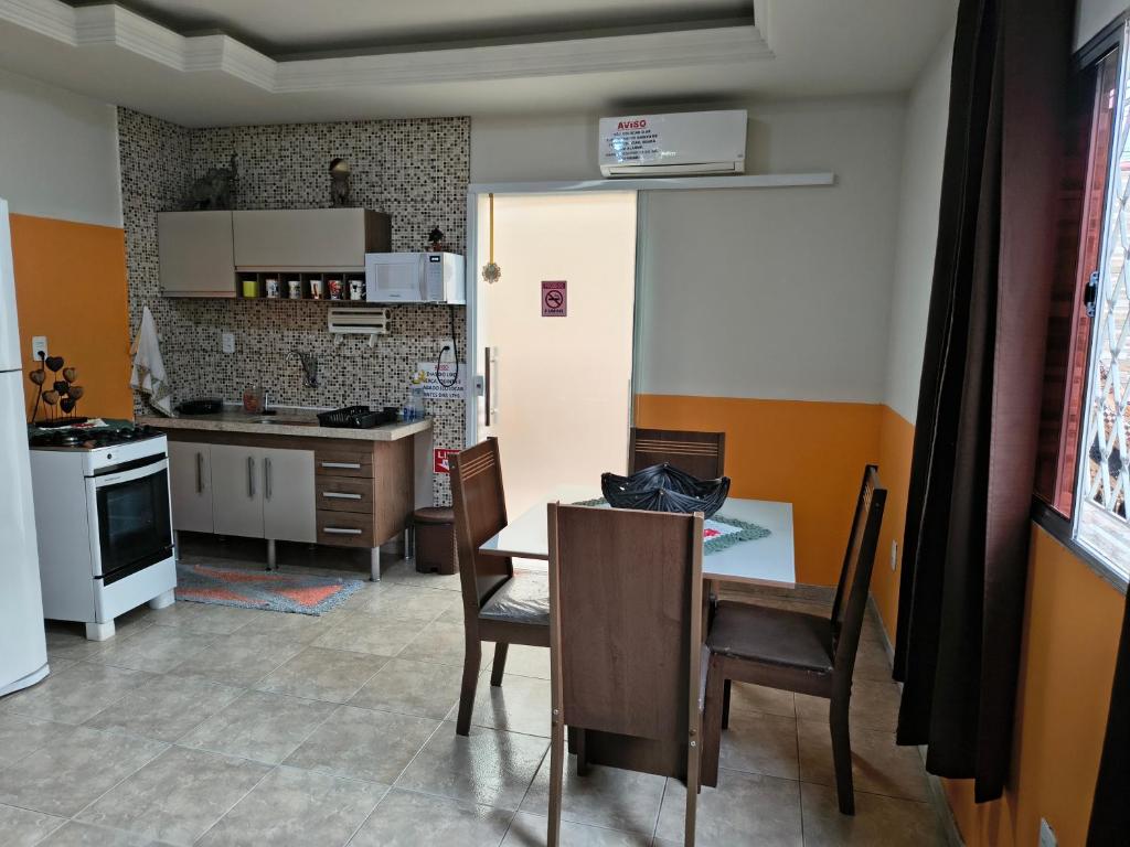 Casa Da Vovó Helena في فيلا فيلها: مطبخ مع طاولة وكراسي وغرفة طعام