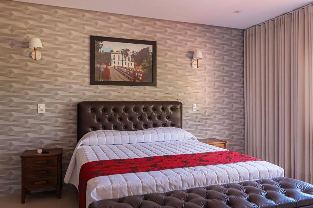 ein Schlafzimmer mit einem großen Bett mit einer roten und weißen Decke in der Unterkunft Pousada Dona Bili in Pirenópolis