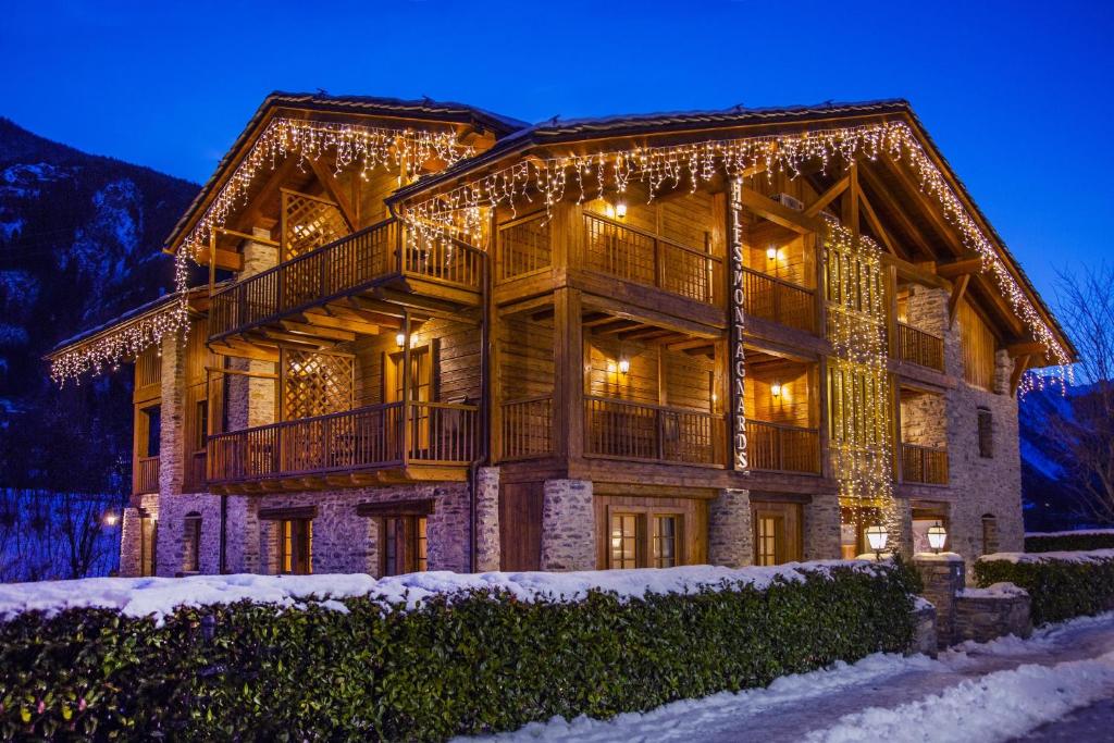 een groot houten huis met kerstverlichting bij Appartamento Montagnards in Morgex
