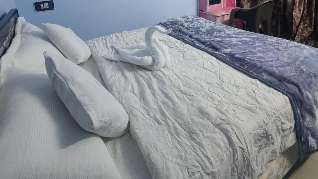 普杰Shiv Shakti Home Stay - Bhuj的一张床上放着天鹅和枕头