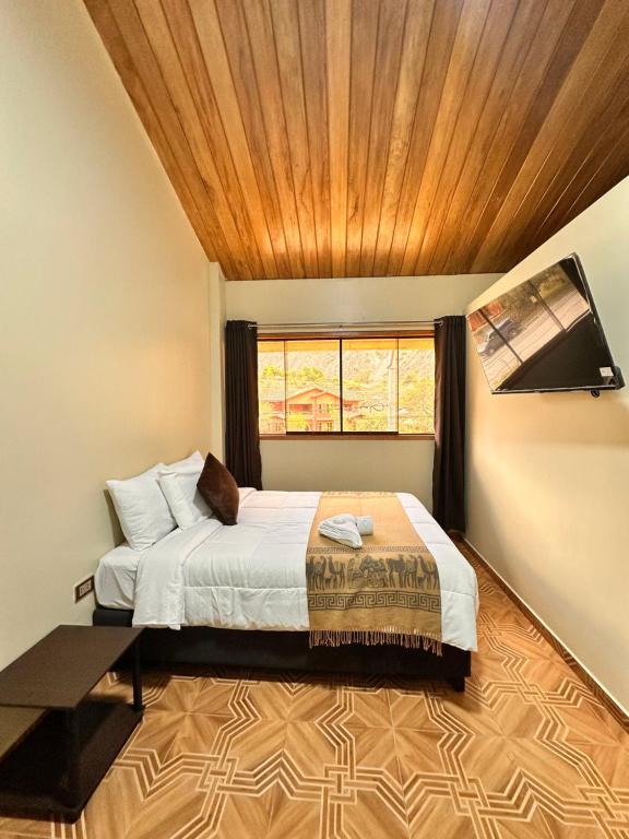 een slaapkamer met een bed met een houten plafond bij Andher Palace Hotel in Ollantaytambo