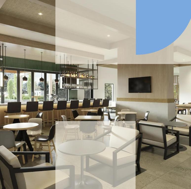 a restaurant with tables and chairs and a bar at Hyatt House At Ho'Opili in Ewa Beach