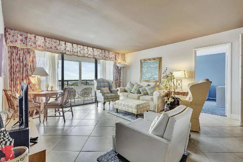een woonkamer met een bank, een tafel en stoelen bij Luxury Two-Bedroom Oceanfront Apartment With Panoramic Views in South Palm Beach