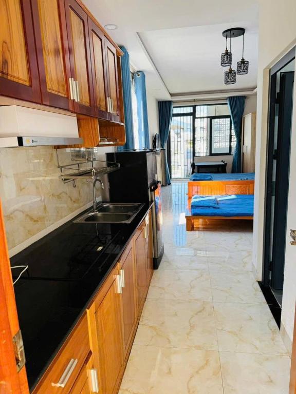 a kitchen with a sink and a room with a bed at The Wooden Nest Studio Nha Trang Center in Nha Trang