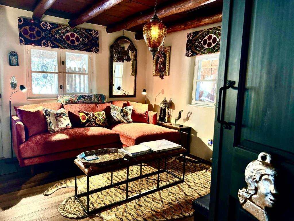 un soggiorno con un divano rosso e un tavolo di Historic Adobe 1 acre compound ultimate Santa Fe immersion Classic & Dreamy a Santa Fe