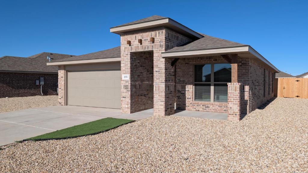 een huis met een garage met een oprit bij Immaculate 4BR New Construction Home in Lubbock
