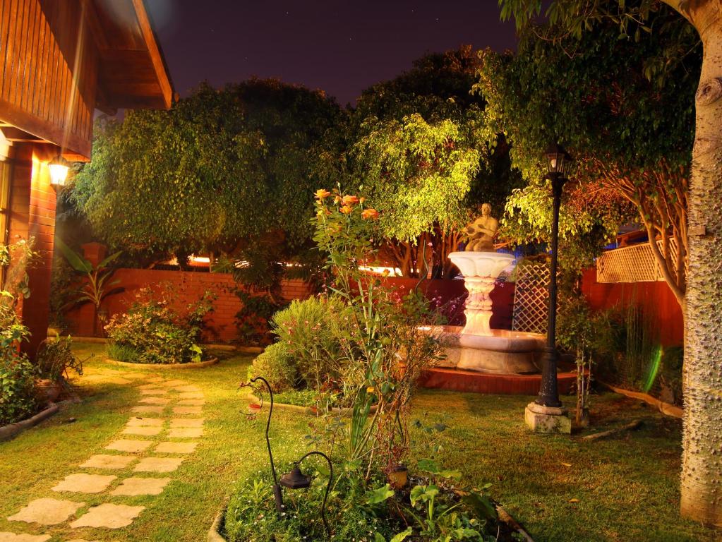 a garden at night with a fountain in the yard at Casa Emiluz in La Serena