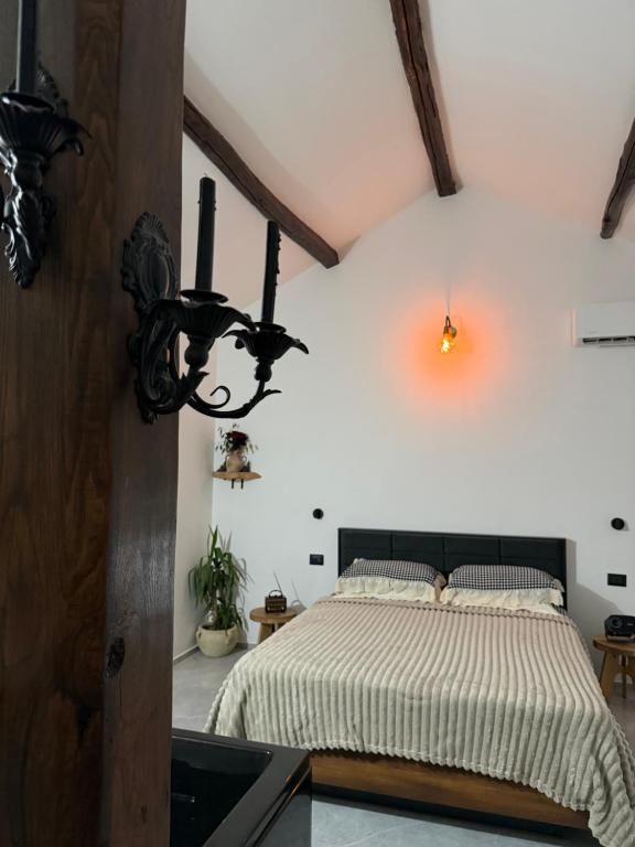 een slaapkamer met een bed en een kroonluchter bij Villa Forgione in Grottaminarda